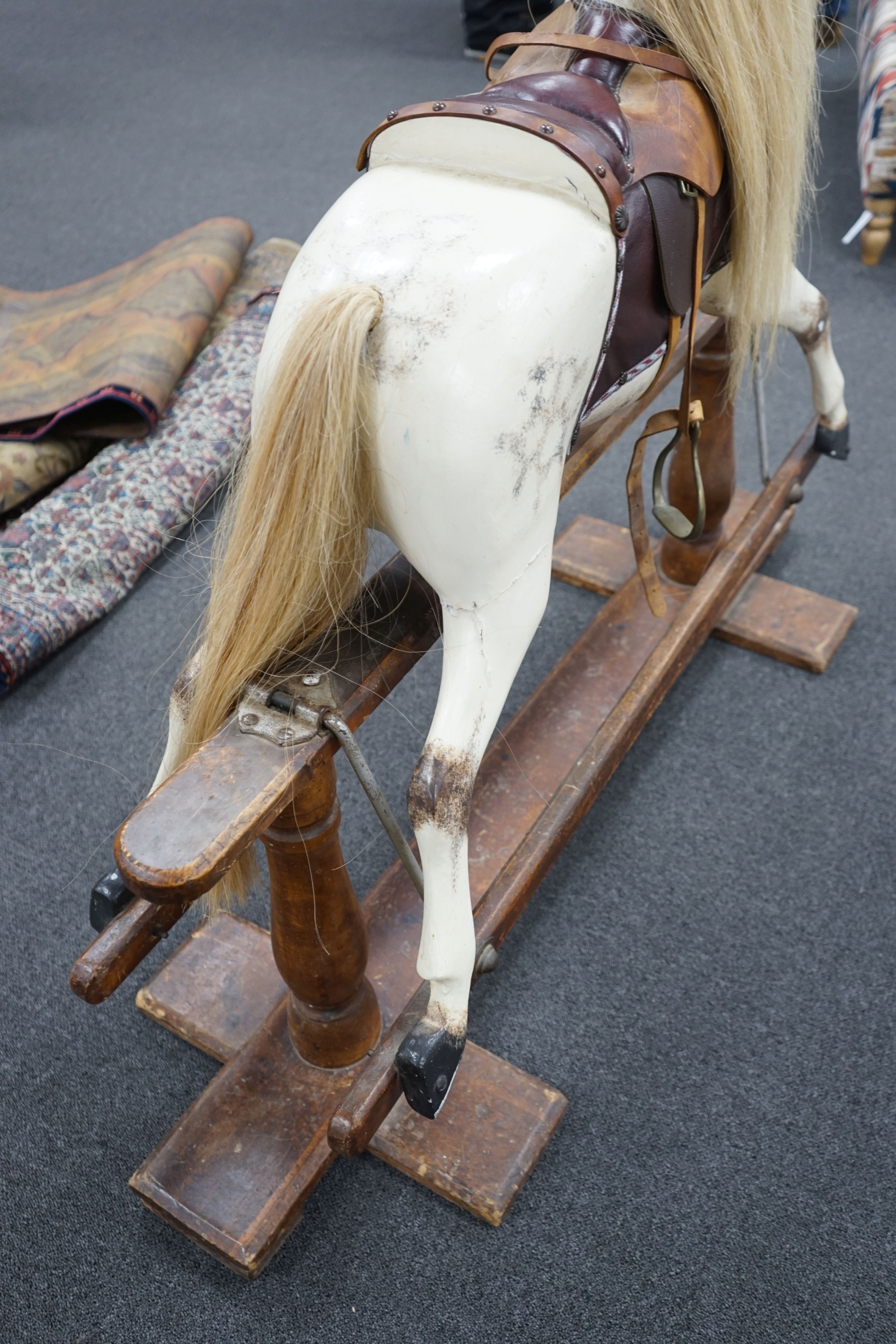 An early 20th century Ayres type dapple grey rocking horse on pine safety frame, width 130cm, height 110cm